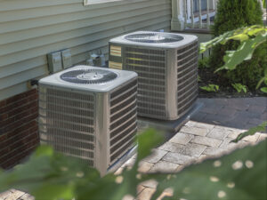 Two AC units outside a home on a sunny day